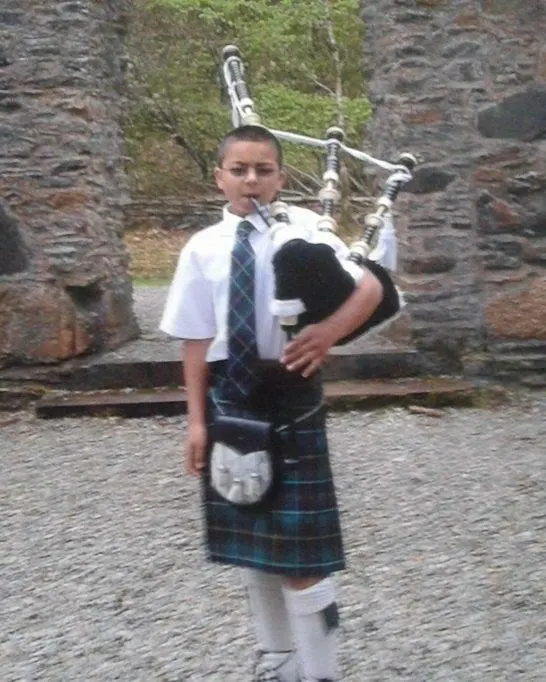 Aaron McInnes as a young piper in his kilt with his pipes