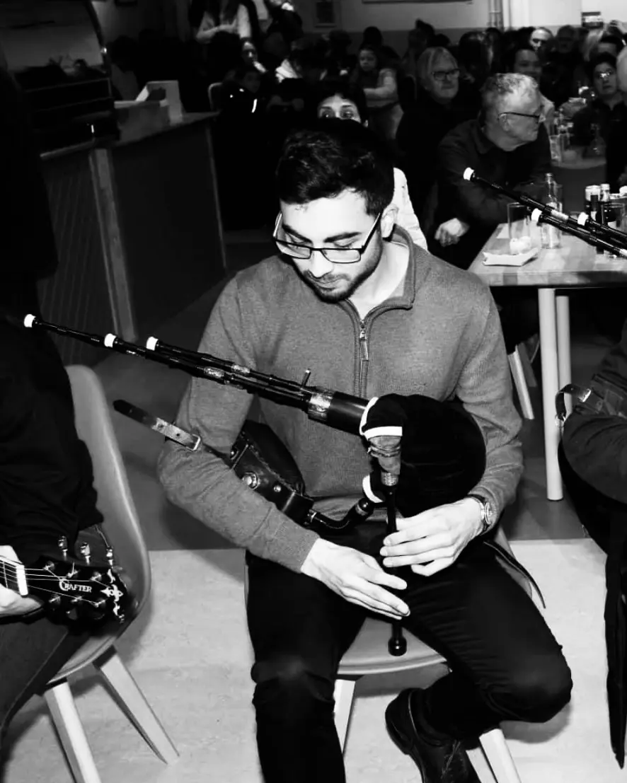 Aaron McInnes playing smallpipes at a traditional music session